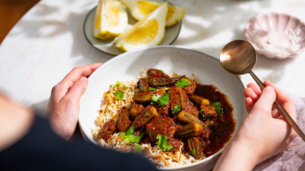 Libanesischer Okra Eintopf (Bamyeh) mit Butterreis serviert mit Zitronenspalten.