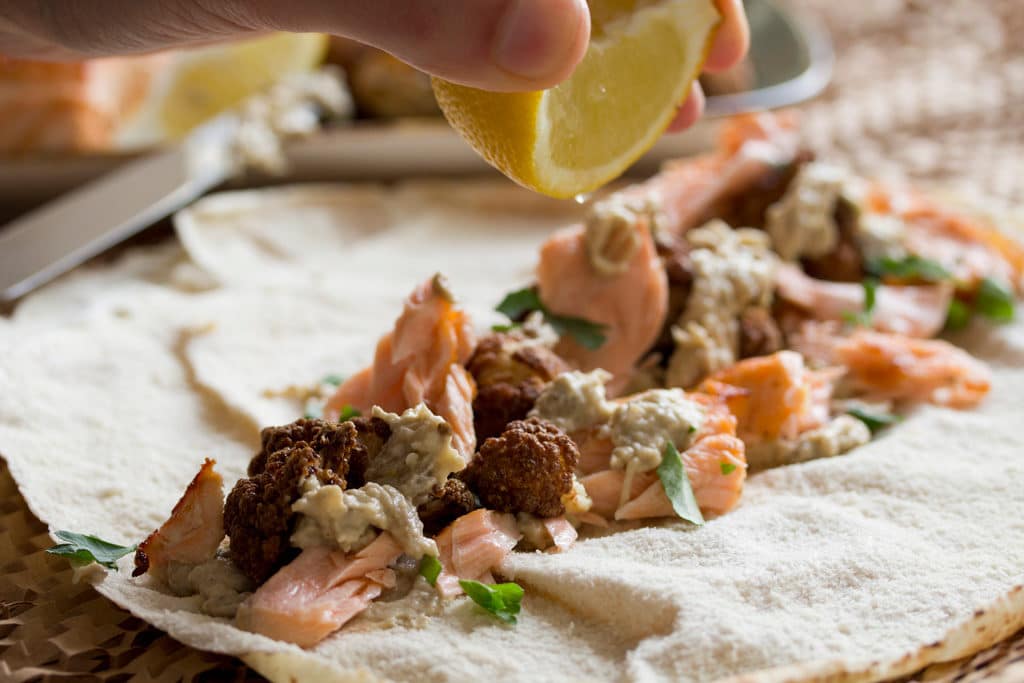 Lachs-Wrap mit frittiertem Blumenkohl wird gerade befüllt.