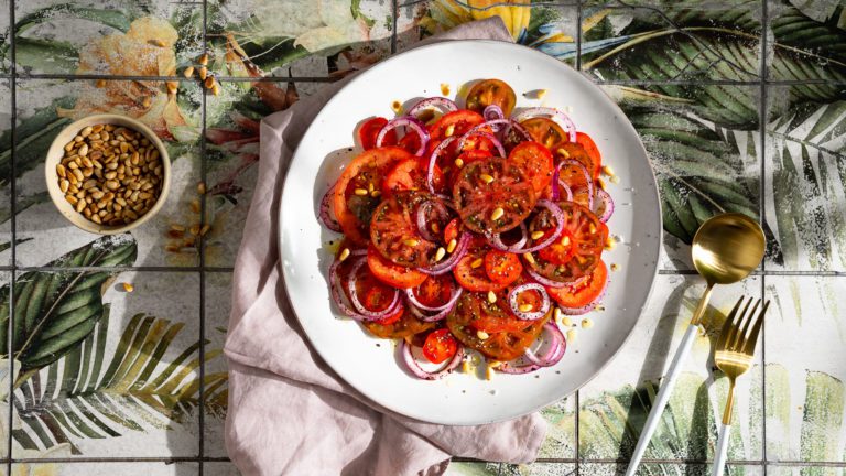 Tomatensalat mit Sumach-Zwiebeln auf einem Teller.