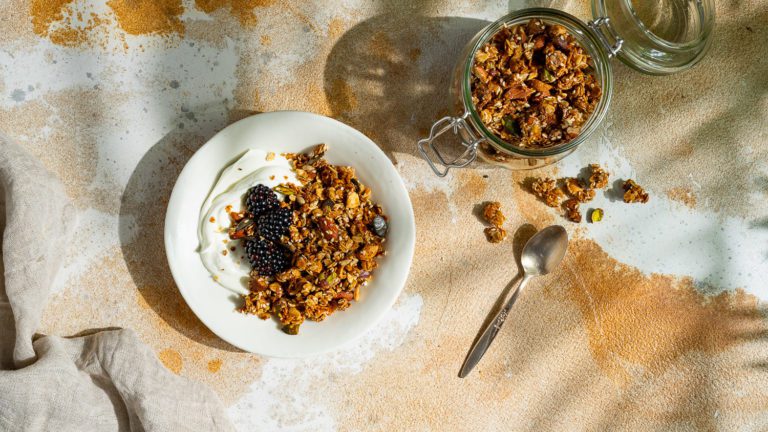 Granola selber machen - Granola mit Pistazien, serviert mit Joghurt und Beeren.