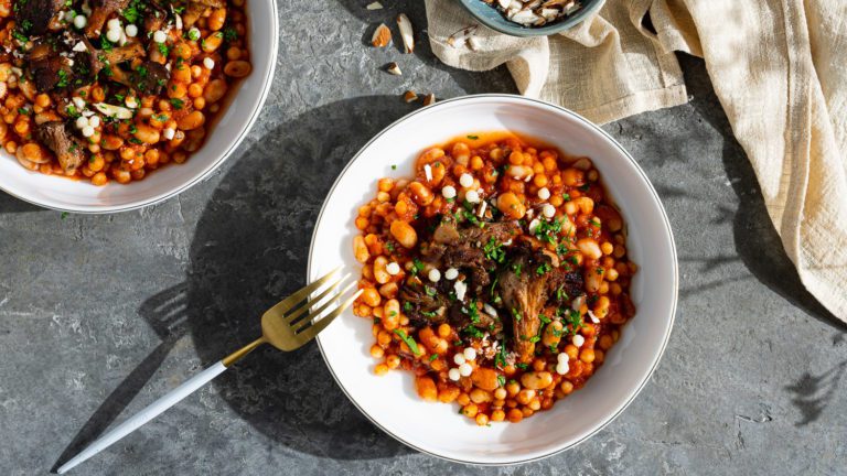 Pearl couscous in tomato sauce with fried mushrooms