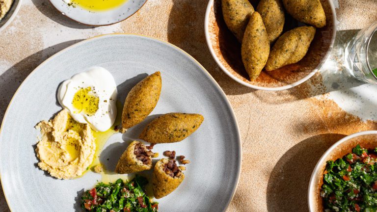 Potato kibbeh croquettes, served with small mezze bowls.