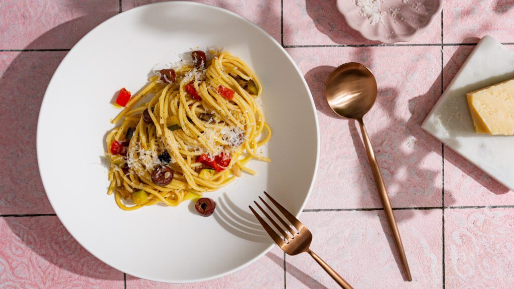 Pasta with vegetables served on a white plate.