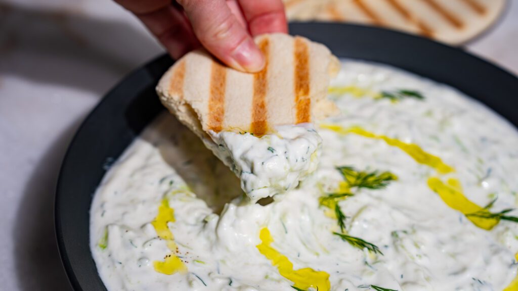 Creamy tzatziki on a piece of pita.