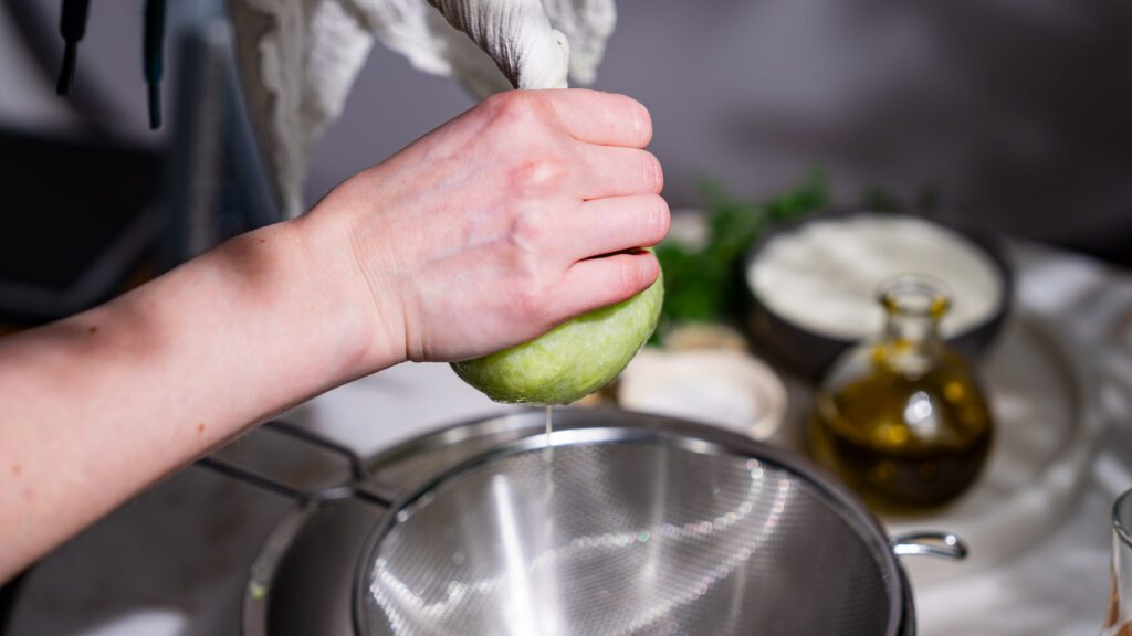 A grated cucumber is being drained in a straining cloth for Greek tzatziki.