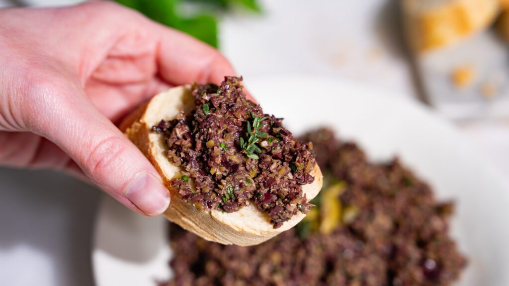 Tapenade d'olives sur un morceau de baguette.