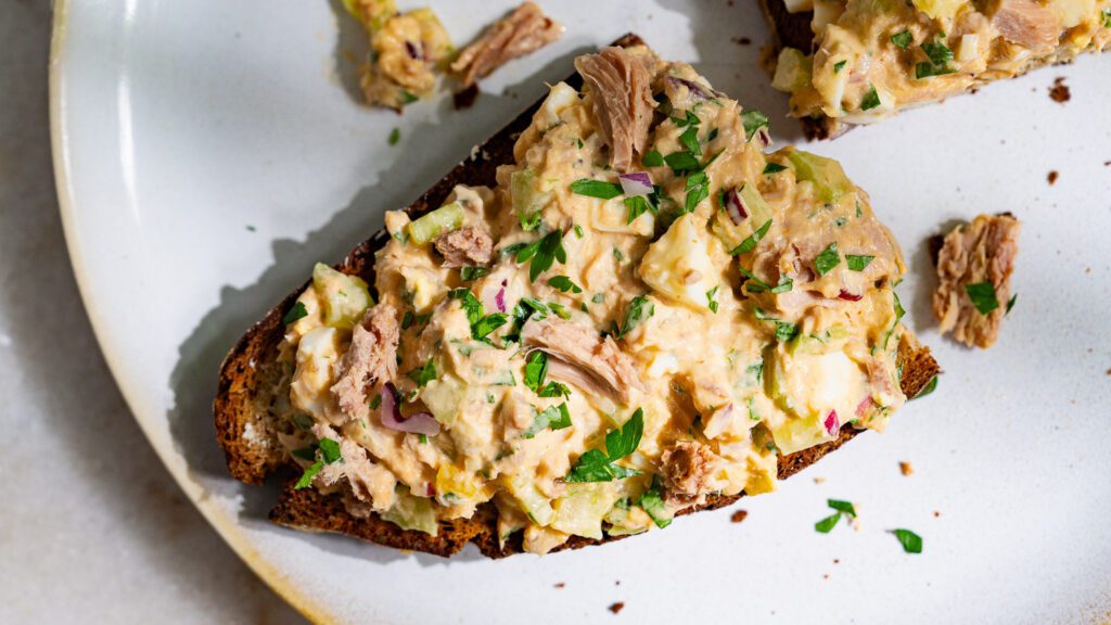 Tuna salad with mayo and egg on a slice of bread.