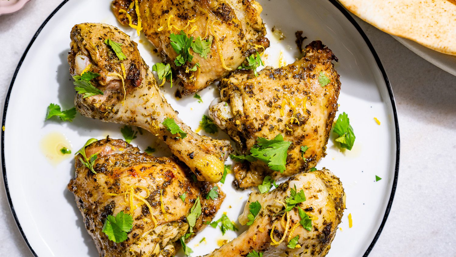 Lemon chicken lies in pieces on a plate.