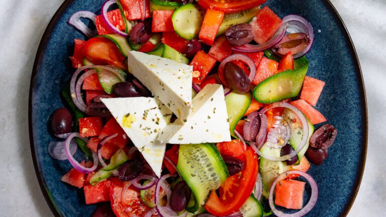 Griechischer Salat mit Wassermelone auf einem Teller serviert.