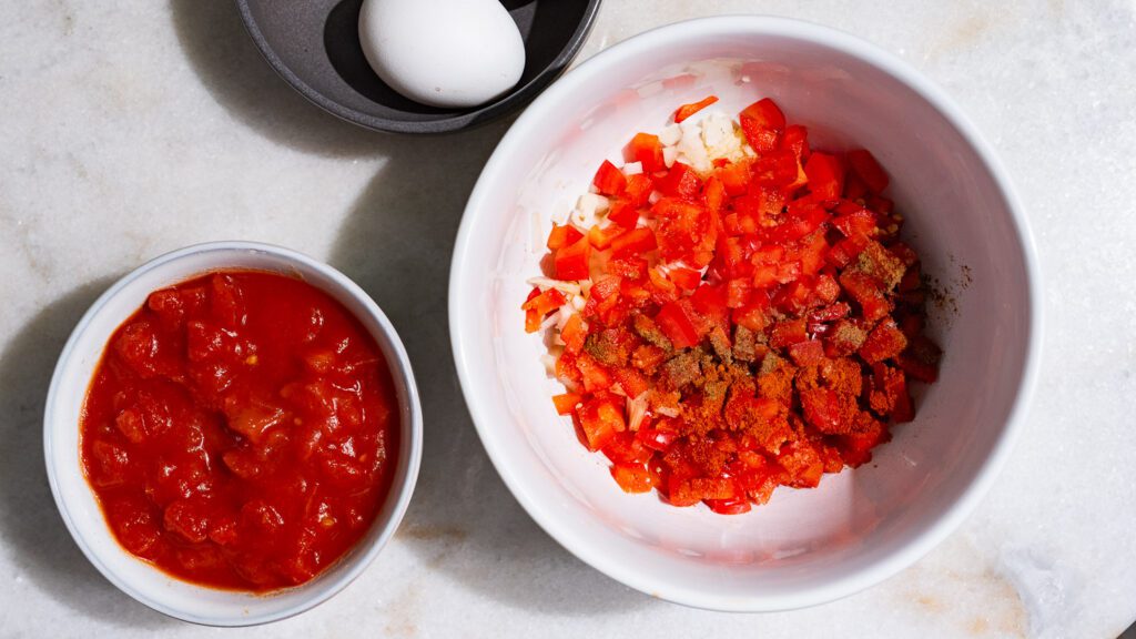 Los cuencos de tomates troceados y los cuencos de verduras troceadas están uno al lado del otro.