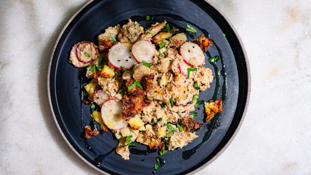 Smashed potato salad arranged on a plate and served.