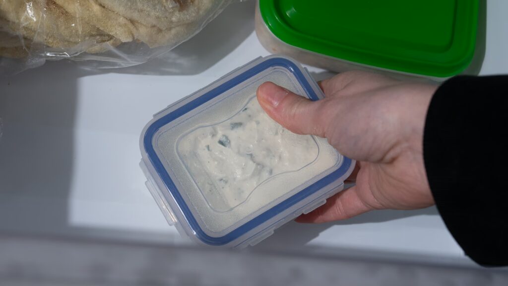 Congelar tzatziki es fácil. Una caja fresca de tzatziki acaba de ser colocada en el congelador.