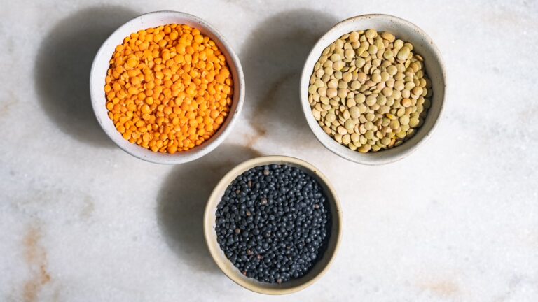 Trois sortes de lentilles dans de petites coupelles sur une table